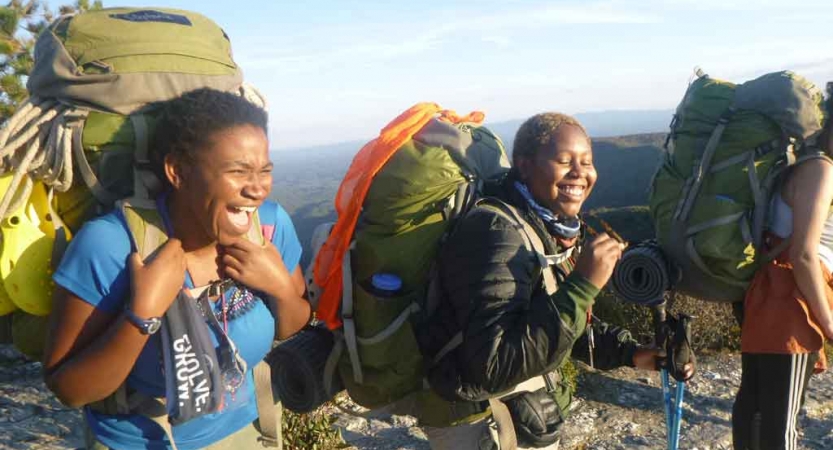 a group of gap year students laugh while on a summit overlooking the blue ridge mountains in north carolina